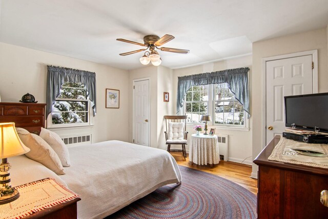 bedroom featuring radiator, ceiling fan, and light wood-type flooring