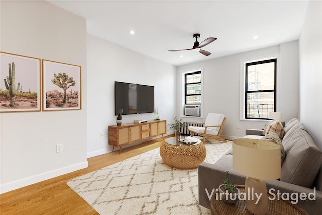 living room featuring hardwood / wood-style flooring, radiator heating unit, ceiling fan, and cooling unit