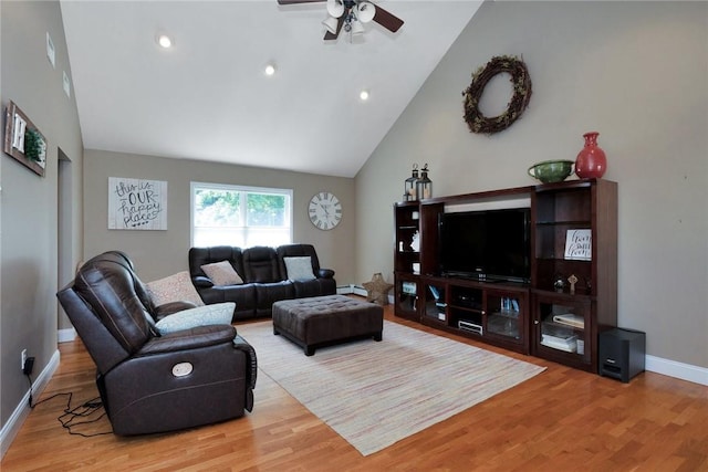 living room featuring baseboards, high vaulted ceiling, and wood finished floors