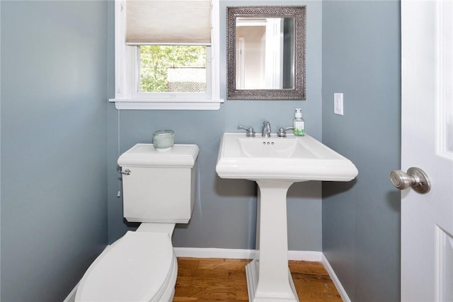 half bathroom with baseboards and toilet