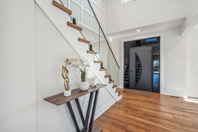 entrance foyer with hardwood / wood-style floors and a high ceiling