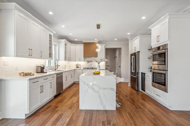 kitchen with stainless steel appliances, white cabinetry, and a kitchen island