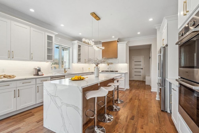 kitchen with white cabinetry, light hardwood / wood-style floors, a center island, and stainless steel refrigerator