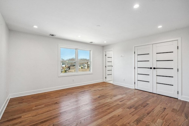 unfurnished bedroom with hardwood / wood-style floors and a closet