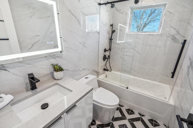 full bathroom with vanity, toilet, and combined bath / shower with glass door