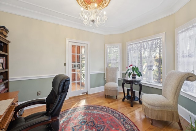 office space with wood finished floors, a healthy amount of sunlight, baseboards, and an inviting chandelier