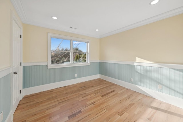 unfurnished room with light wood-style flooring, recessed lighting, visible vents, wainscoting, and crown molding