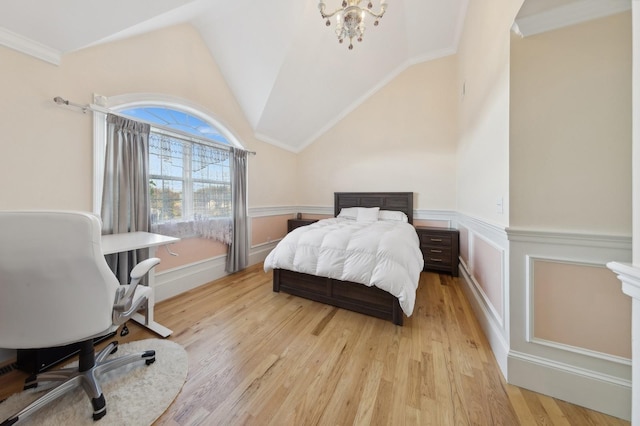 bedroom featuring lofted ceiling, light wood finished floors, a chandelier, and a wainscoted wall