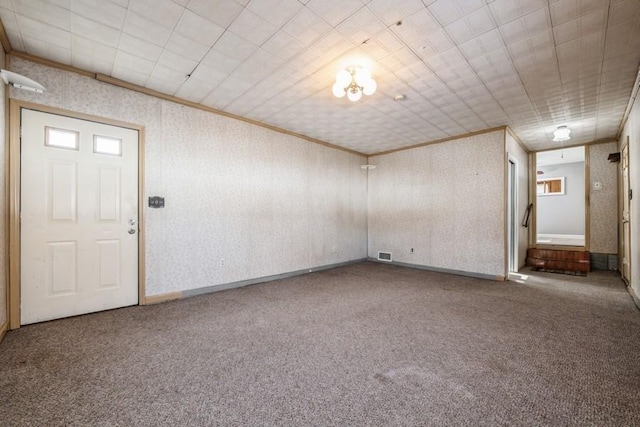 spare room featuring ornamental molding and carpet