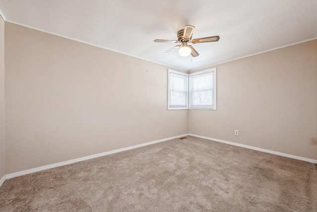 empty room featuring crown molding, carpet, and ceiling fan