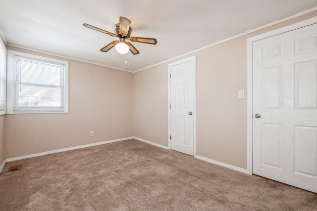 carpeted empty room with ornamental molding and ceiling fan