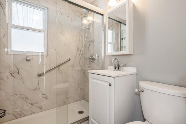 bathroom with vanity, a shower with shower door, and toilet