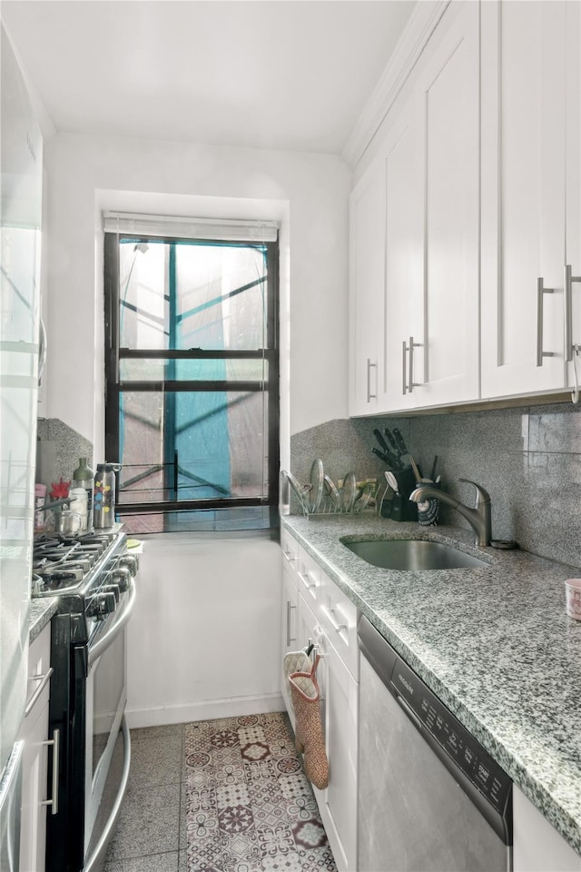 kitchen featuring sink, white cabinetry, stainless steel appliances, tasteful backsplash, and light stone countertops