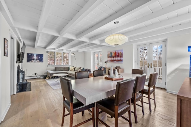 dining space with french doors, beam ceiling, a baseboard heating unit, light wood-type flooring, and baseboards