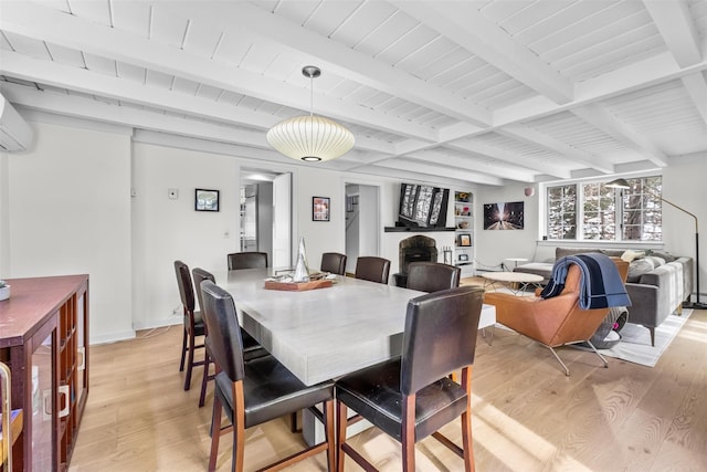 dining room with beam ceiling, light wood-style flooring, and baseboards