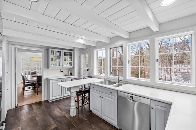 kitchen with light countertops, glass insert cabinets, white cabinets, a sink, and dishwasher