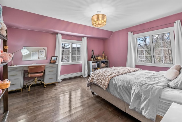 bedroom featuring vaulted ceiling, dark wood-style flooring, baseboard heating, and an inviting chandelier