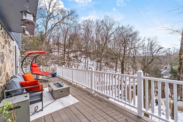 snow covered deck featuring a fire pit