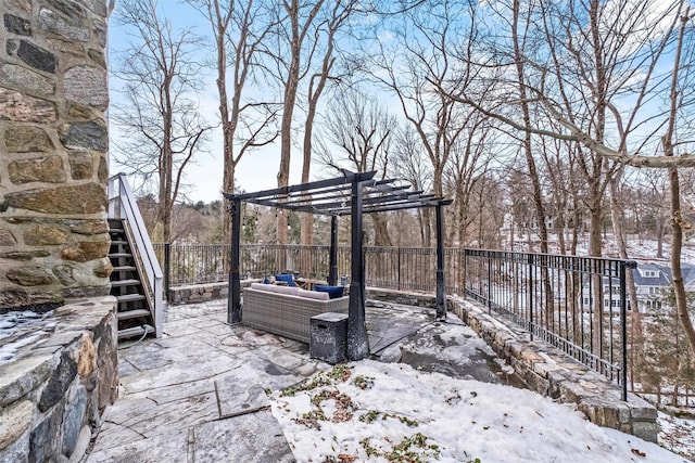 snow covered patio featuring fence and a pergola