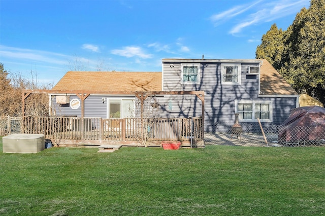 rear view of property featuring a wooden deck and a lawn