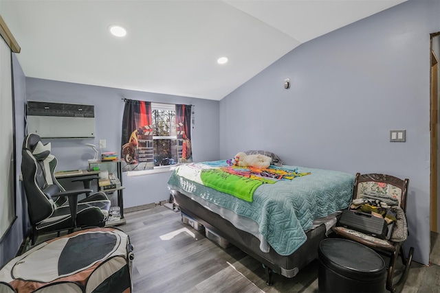 bedroom featuring hardwood / wood-style flooring, lofted ceiling, and a wall mounted air conditioner