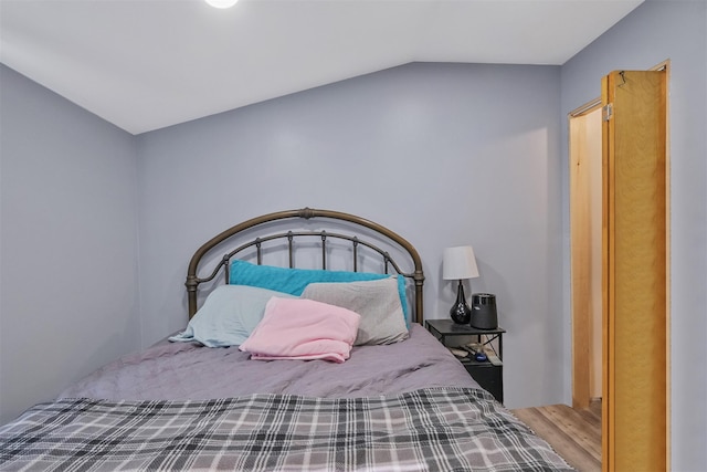 bedroom with hardwood / wood-style flooring and vaulted ceiling