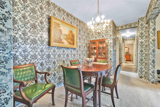 carpeted dining space featuring a chandelier