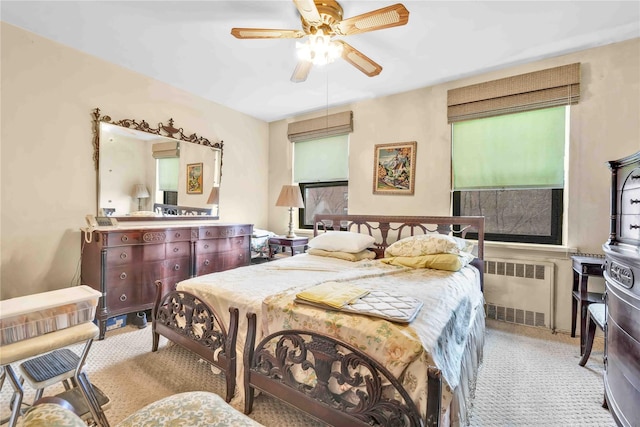 bedroom featuring radiator heating unit, light colored carpet, and ceiling fan