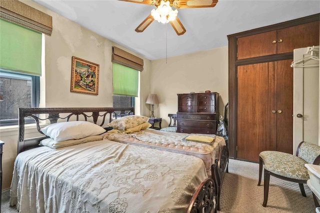 carpeted bedroom with ceiling fan and a closet