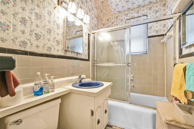 full bathroom with enclosed tub / shower combo, vanity, toilet, and tile walls