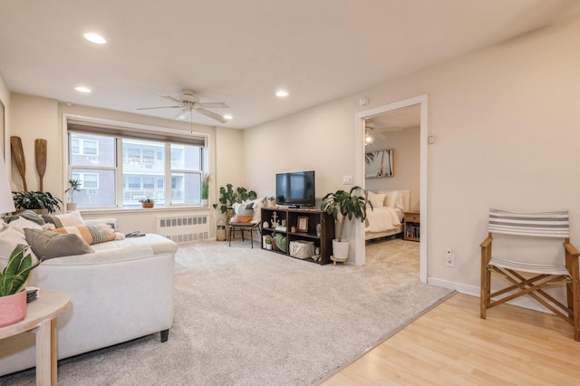 living room featuring wood-type flooring, radiator, and ceiling fan