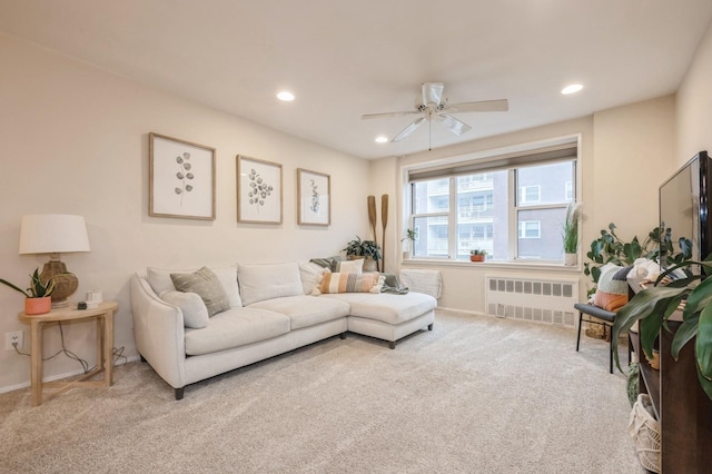 carpeted living room featuring radiator heating unit and ceiling fan