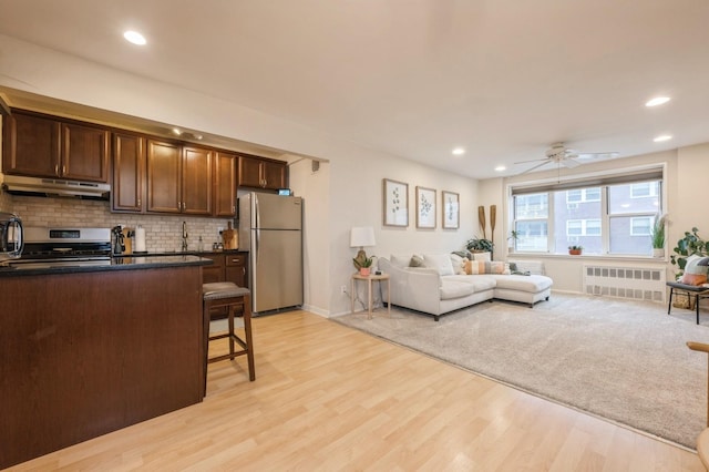 living room with ceiling fan, radiator, and light hardwood / wood-style flooring