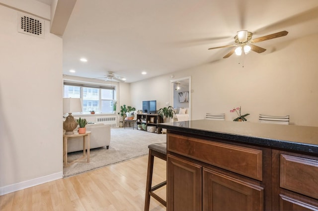 kitchen featuring radiator heating unit, ceiling fan, and light hardwood / wood-style flooring