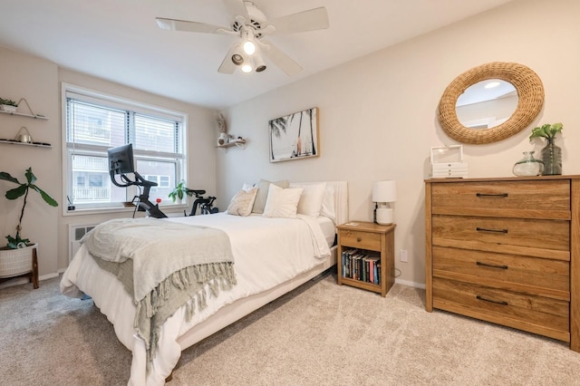 bedroom with ceiling fan, light colored carpet, and radiator heating unit