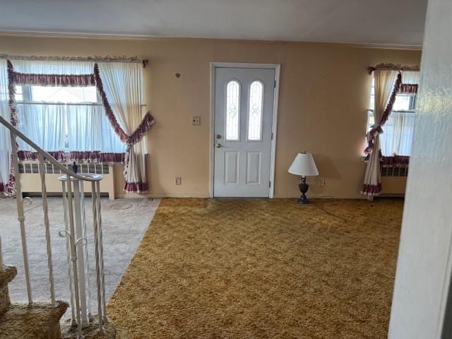 carpeted foyer entrance featuring radiator heating unit