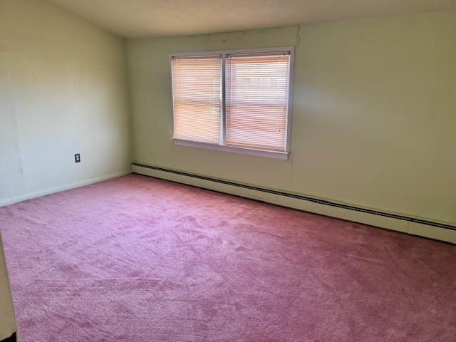 spare room featuring light carpet and baseboard heating