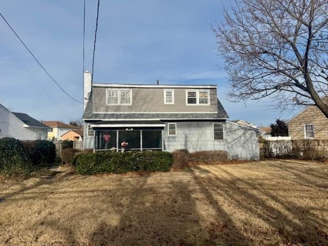 rear view of property with a lawn