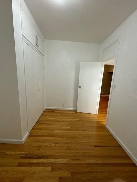 corridor with hardwood / wood-style floors