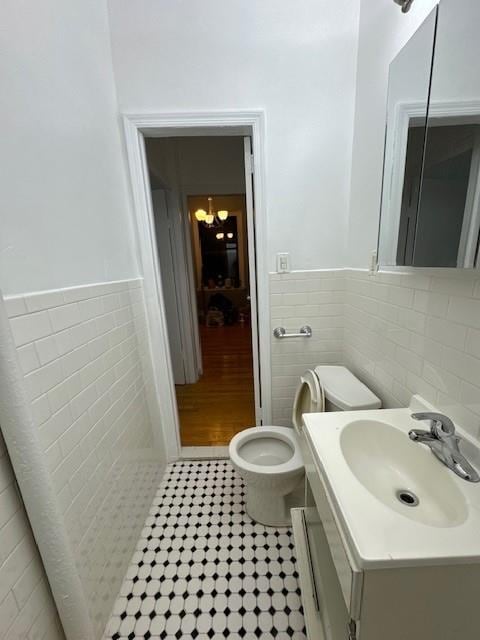 bathroom with vanity, tile walls, tile patterned floors, and toilet