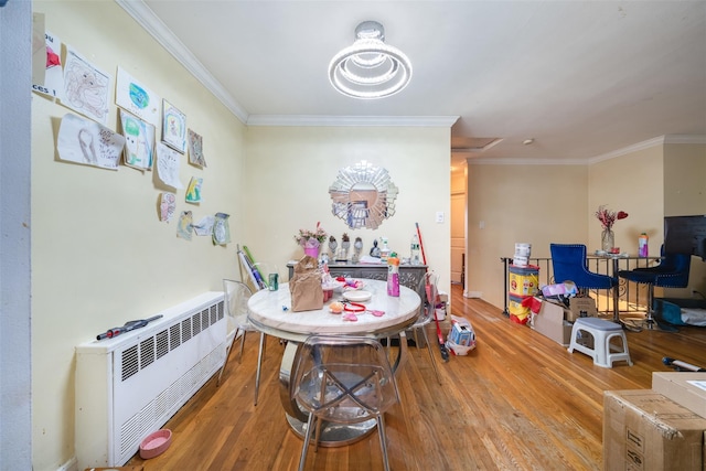 dining room with ornamental molding, heating unit, and hardwood / wood-style floors