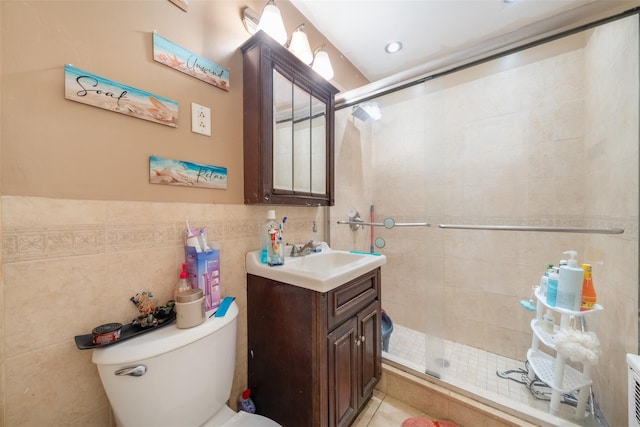 bathroom with vanity, tile walls, toilet, and an enclosed shower