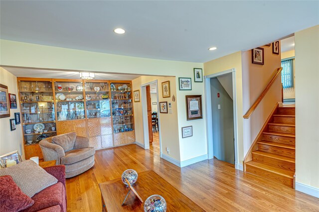 living area with stairway, baseboards, recessed lighting, and wood finished floors