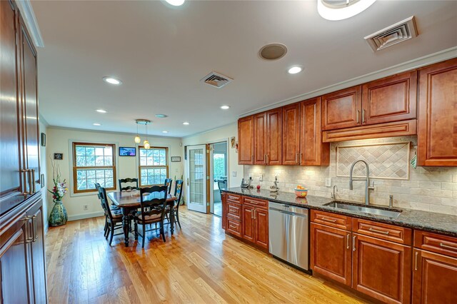 kitchen with visible vents, tasteful backsplash, stainless steel dishwasher, a sink, and light wood-style flooring