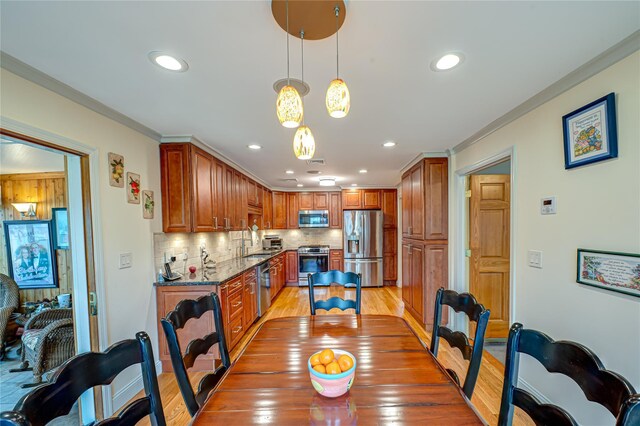 dining room with crown molding, light wood-type flooring, and recessed lighting