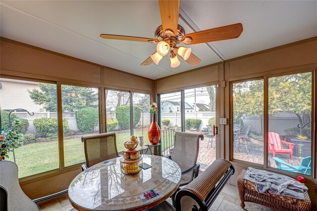sunroom / solarium with outdoor dining area, ceiling fan, stone finish floor, and lofted ceiling