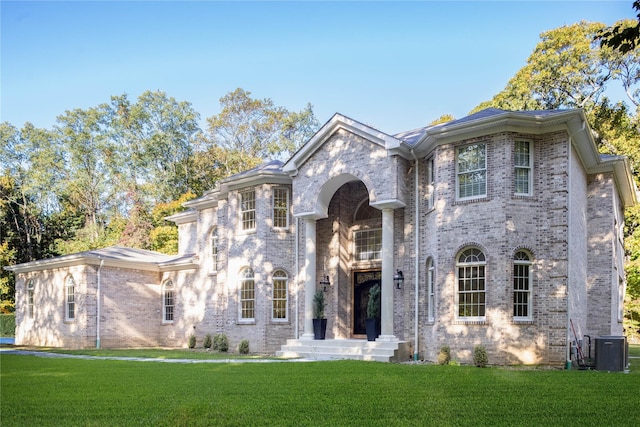 view of front of property with central AC and a front lawn