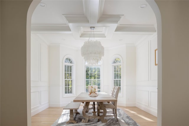 dining area with coffered ceiling, crown molding, a notable chandelier, beamed ceiling, and light hardwood / wood-style floors