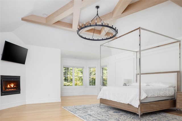 bedroom with beamed ceiling, wood-type flooring, and a notable chandelier