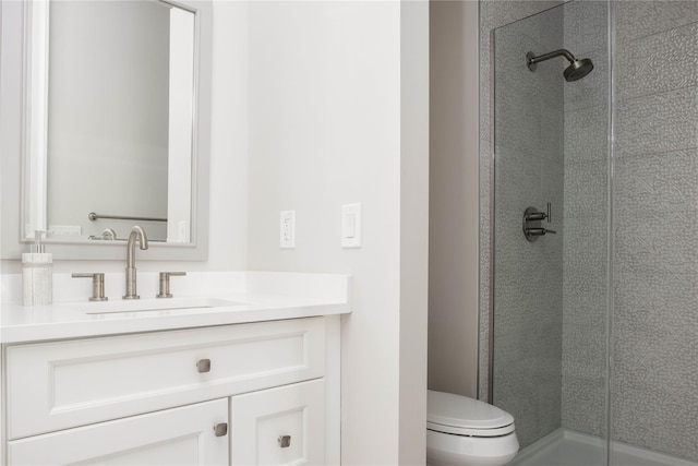 bathroom with an enclosed shower, vanity, and toilet